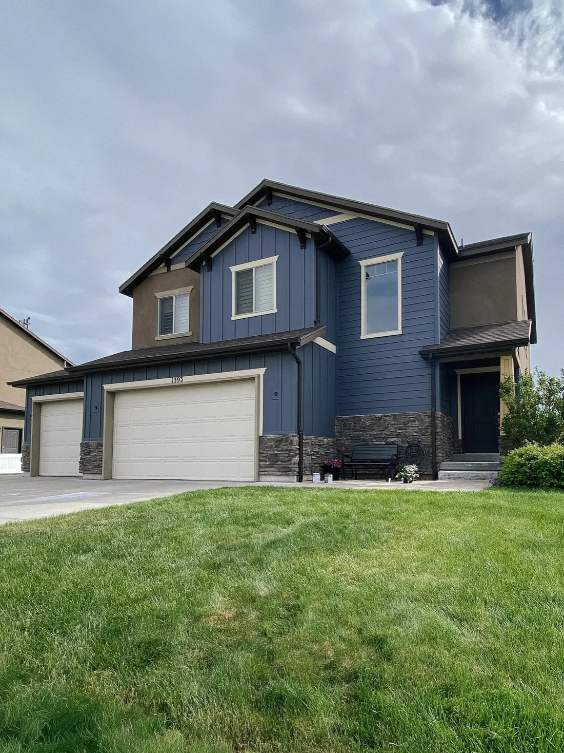 Two story home with freshly painted blue siding and stone accents